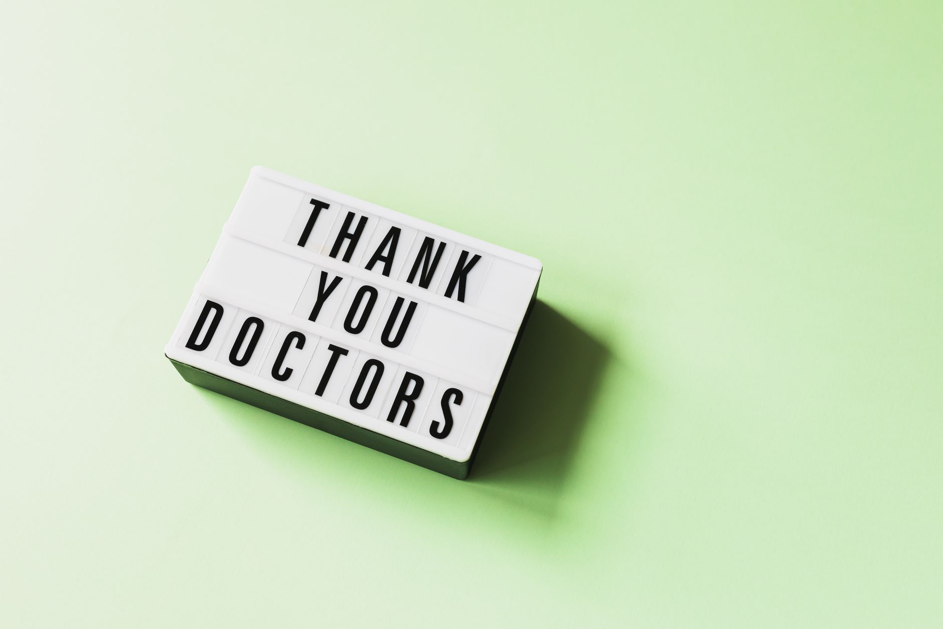 christian thank you messages for support - From above of vintage light box with THANK YOU DOCTORS inscription placed on green surface