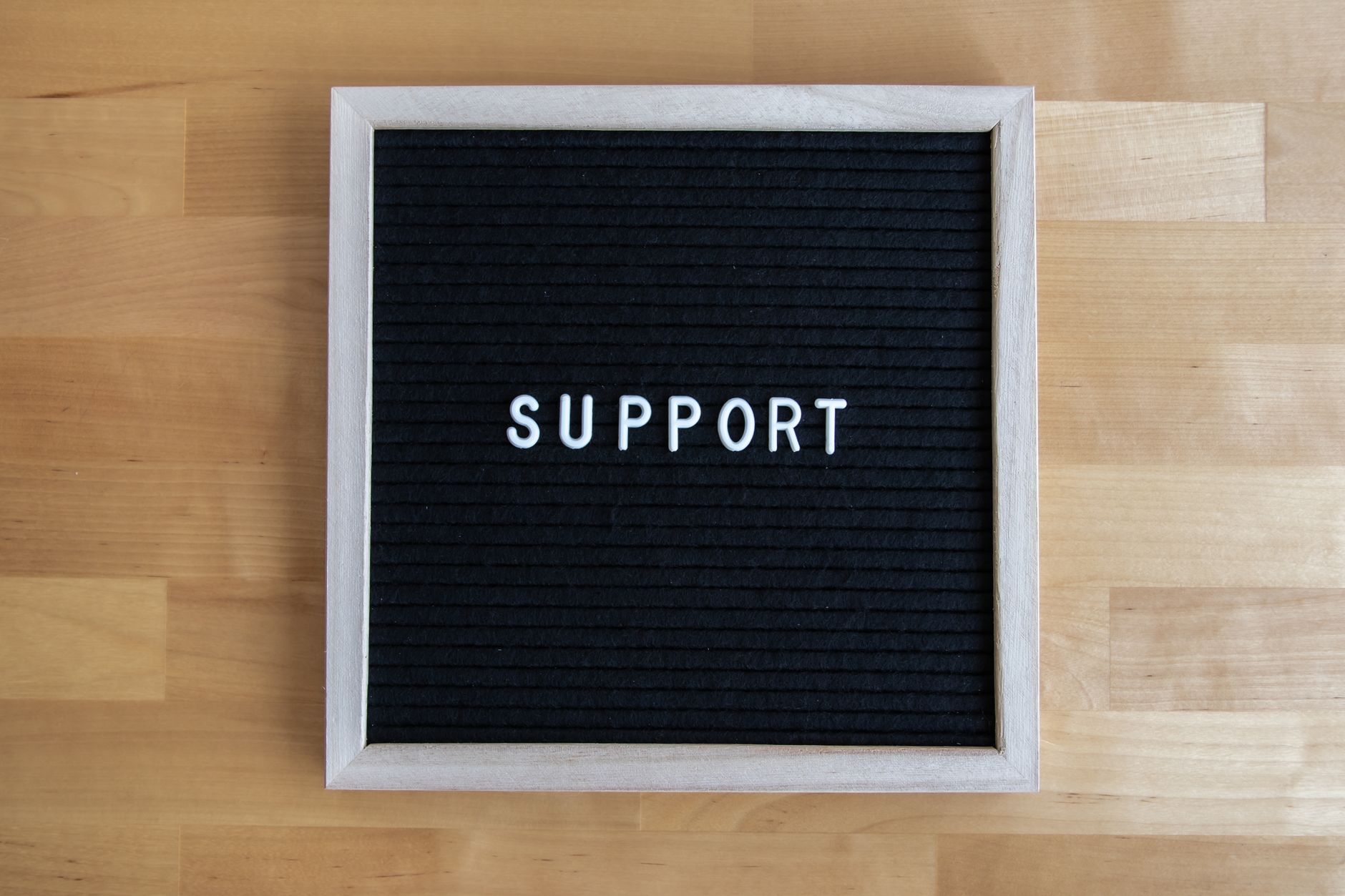 how to message support on outlier - Black letter board displaying the word SUPPORT on a wooden table, offering ample copyspace.