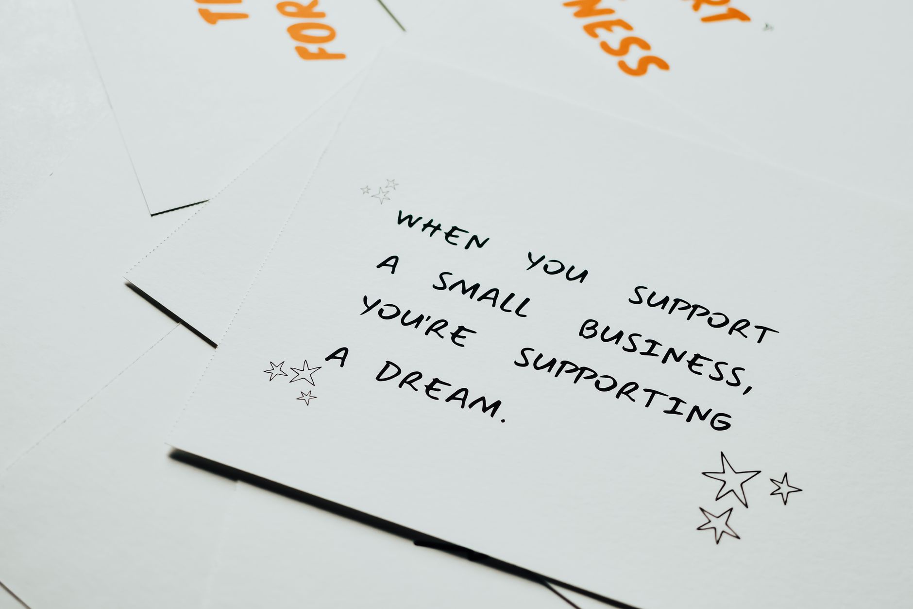 how to message support on outlier - Motivational note on white paper about supporting small businesses with decorative stars.