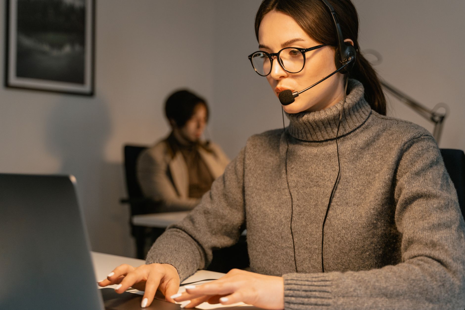Message Support Strategies for Remote Teams - Professional woman wearing headset working in customer support, focused on her tasks.