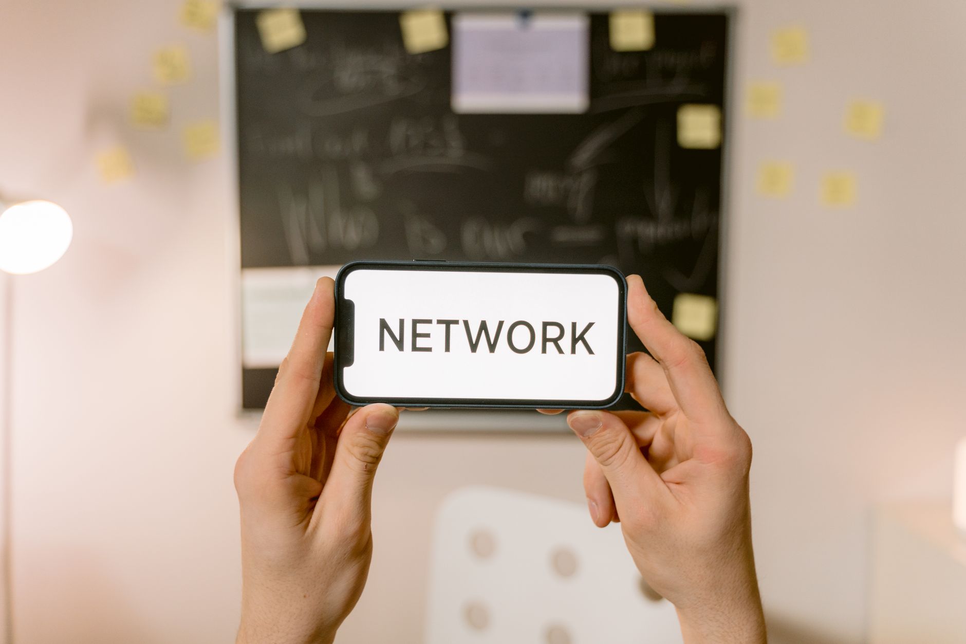 multimedia messages not supported by network - Hands holding a smartphone with 'NETWORK' text on screen, concept of digital communication.