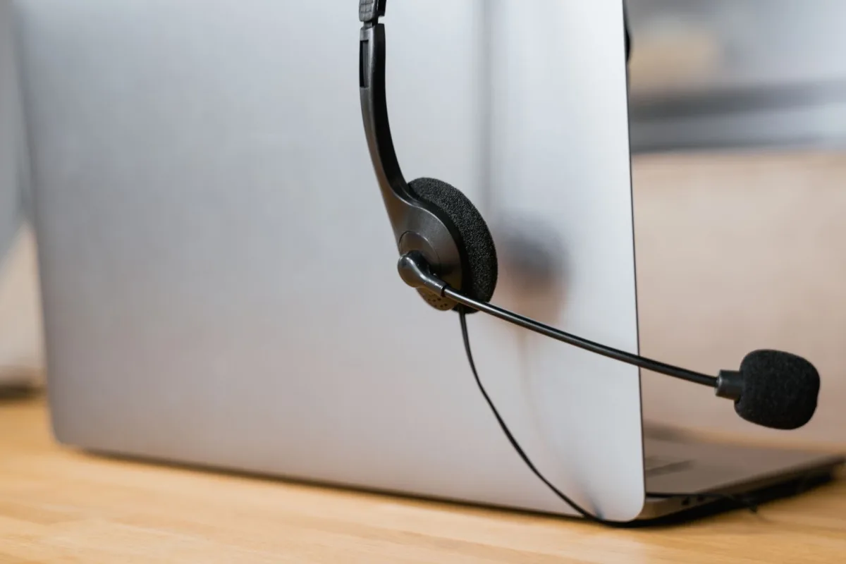 A laptop with a headset attached, ideal for virtual meetings or online