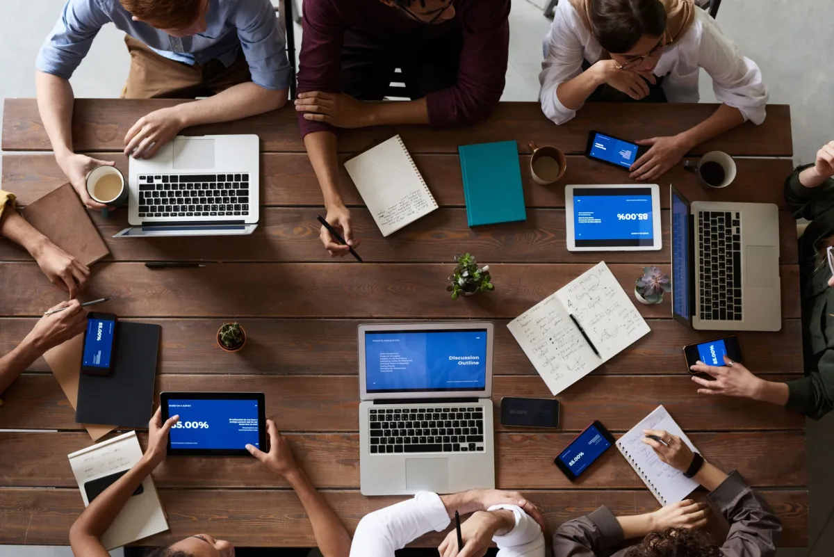 Overhead view of a diverse in a business meeting using laptops and tablets.