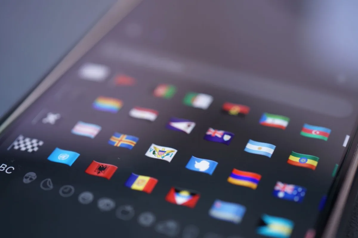 Close-up of a smartphone screen displaying a variety of world flags emojis used digital Close-up of a smartphone screen displaying a variety of world flags emojis used digital