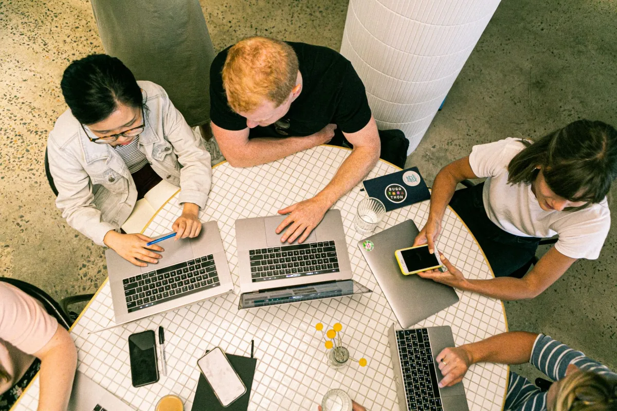 Top view of diverse team collaboratively working in a modern office setting. Top view of diverse team collaboratively working in a modern office setting.