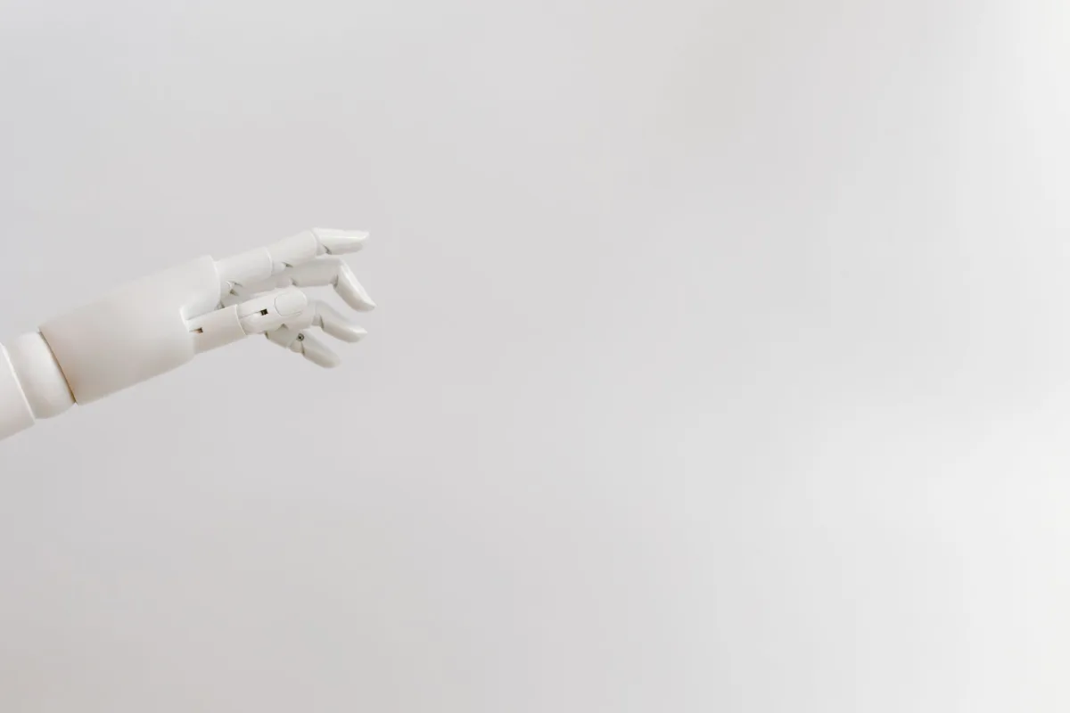 Minimalist image of a robotic hand reaching out on a white background.