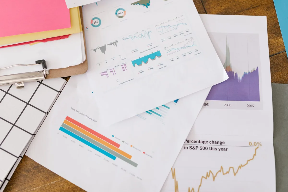Close-up of business charts and graphs on papers and clipboard.