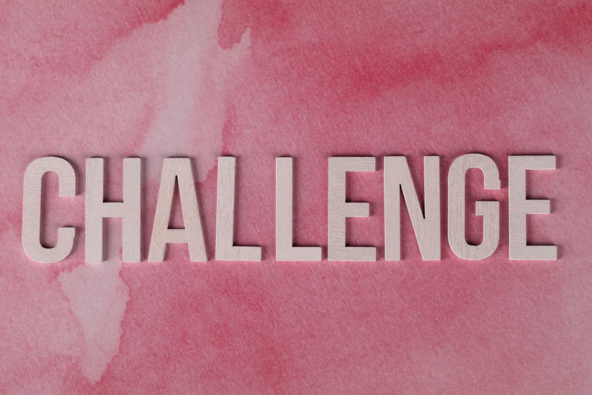 Text 'CHALLENGE' in bold on textured pink watercolor background for motivation.