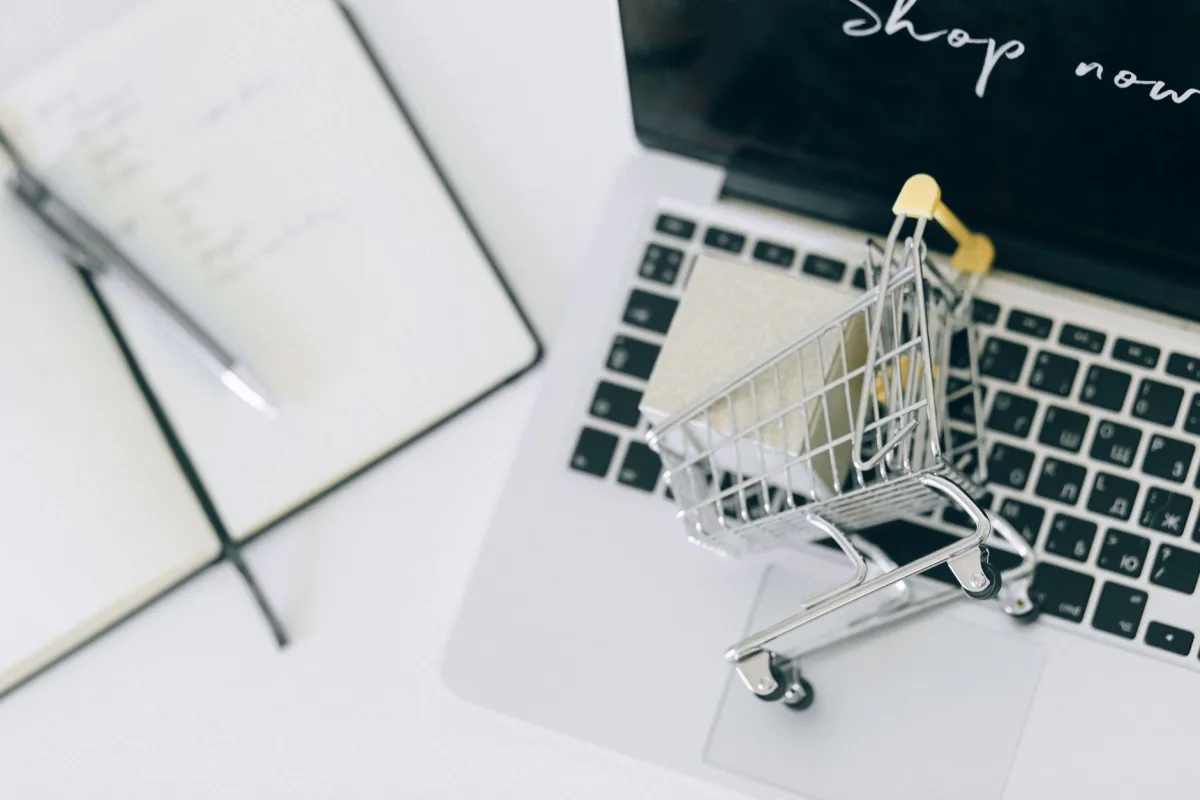 Creative depiction of online shopping with a miniature cart on a laptop keyboard. Creative depiction of online shopping with a miniature cart on a laptop keyboard.