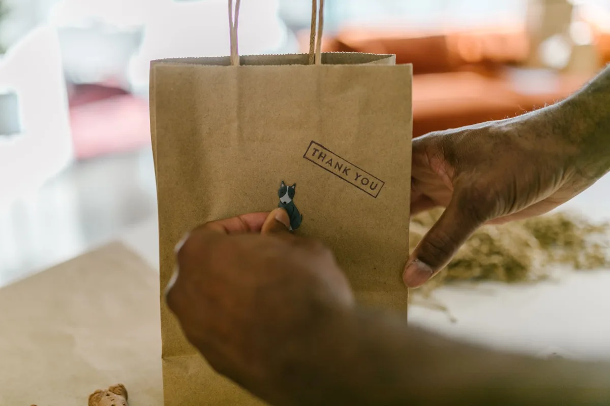 Close-up of hands holding a paper bag, symbolizing gratitude and small business packaging. Close-up of hands holding a paper bag, symbolizing gratitude and small business packaging.