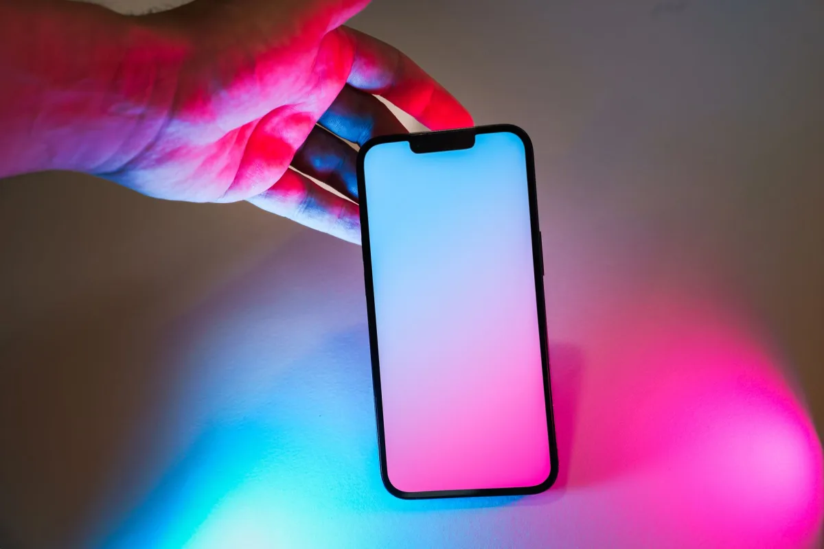 Smartphone with neon pink and blue glow, offering ample copy space for design mockups. Smartphone with neon pink and blue glow, offering ample copy space for design mockups.
