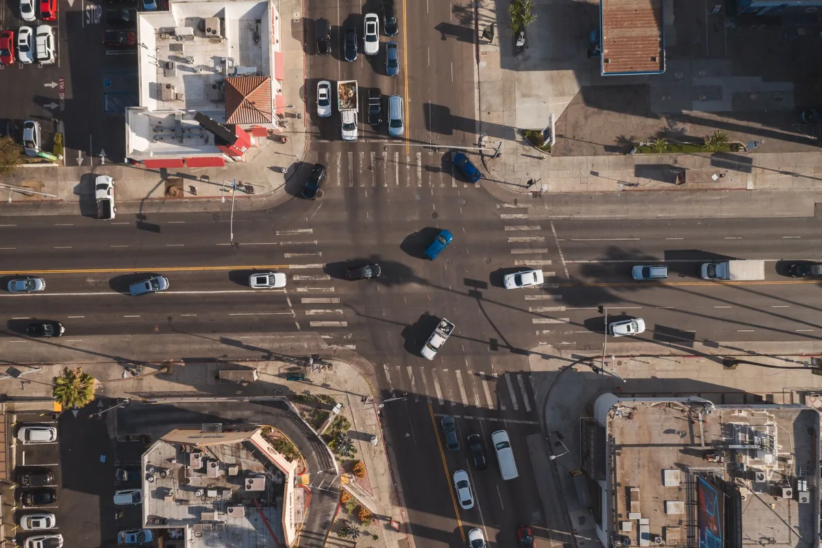 Aerial view of a busy urban intersection with vehicles in motion, showcasing city life and urban planning.