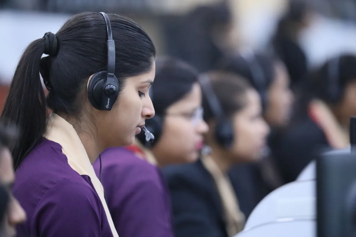 Call center agents wearing headsets working in a focused office environment. Call center agents wearing headsets working in a focused office environment.
