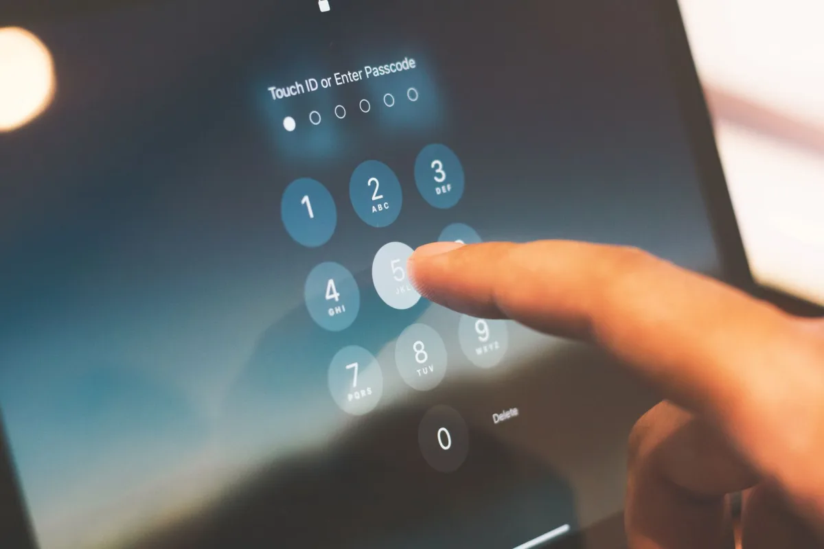 Close-up of a finger entering a passcode on a smartphone screen. Close-up of a finger entering a passcode on a smartphone screen.
