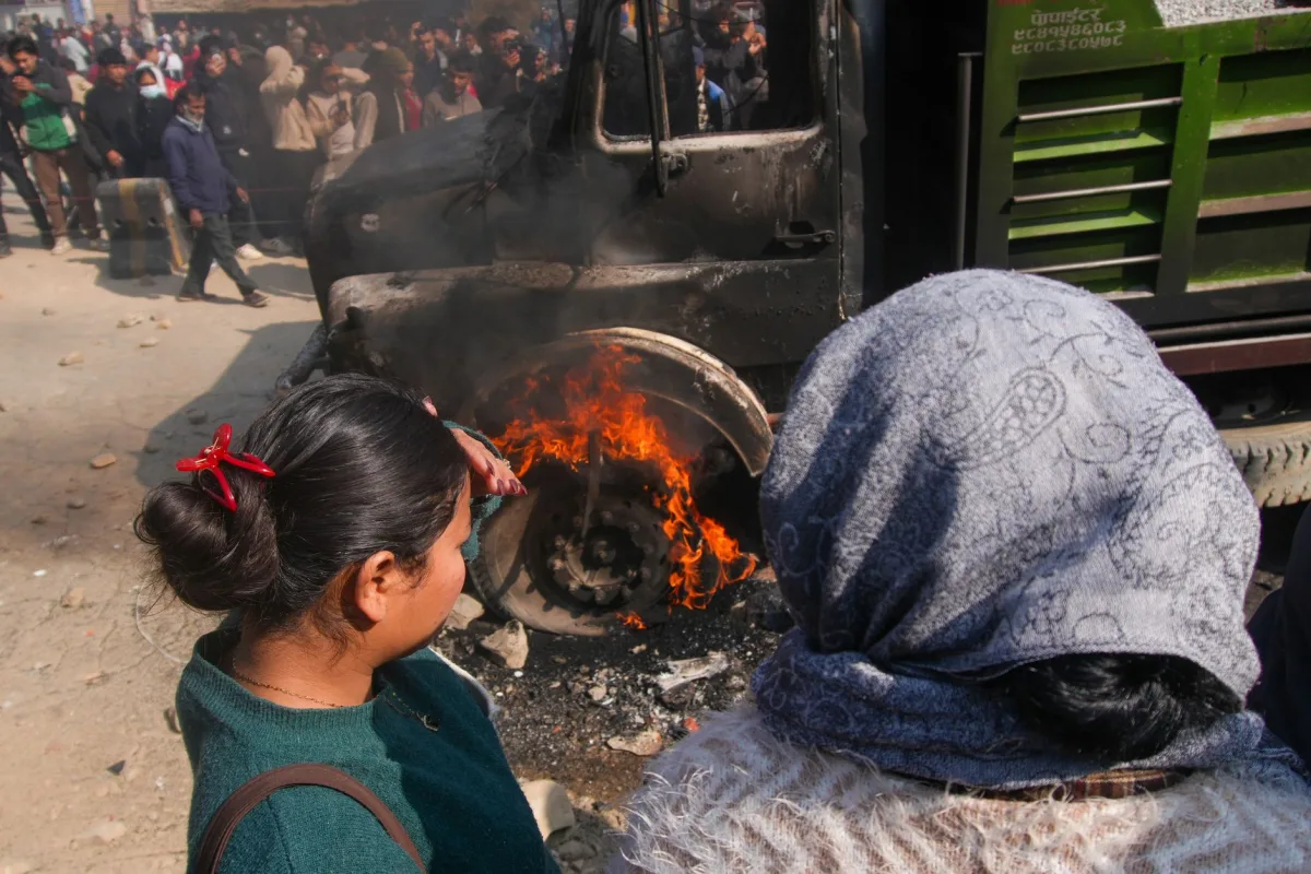 A group of people watch a truck fire in a crowded city street, capturing an intense moment. A group of people watch a truck fire in a crowded city street, capturing an intense moment.