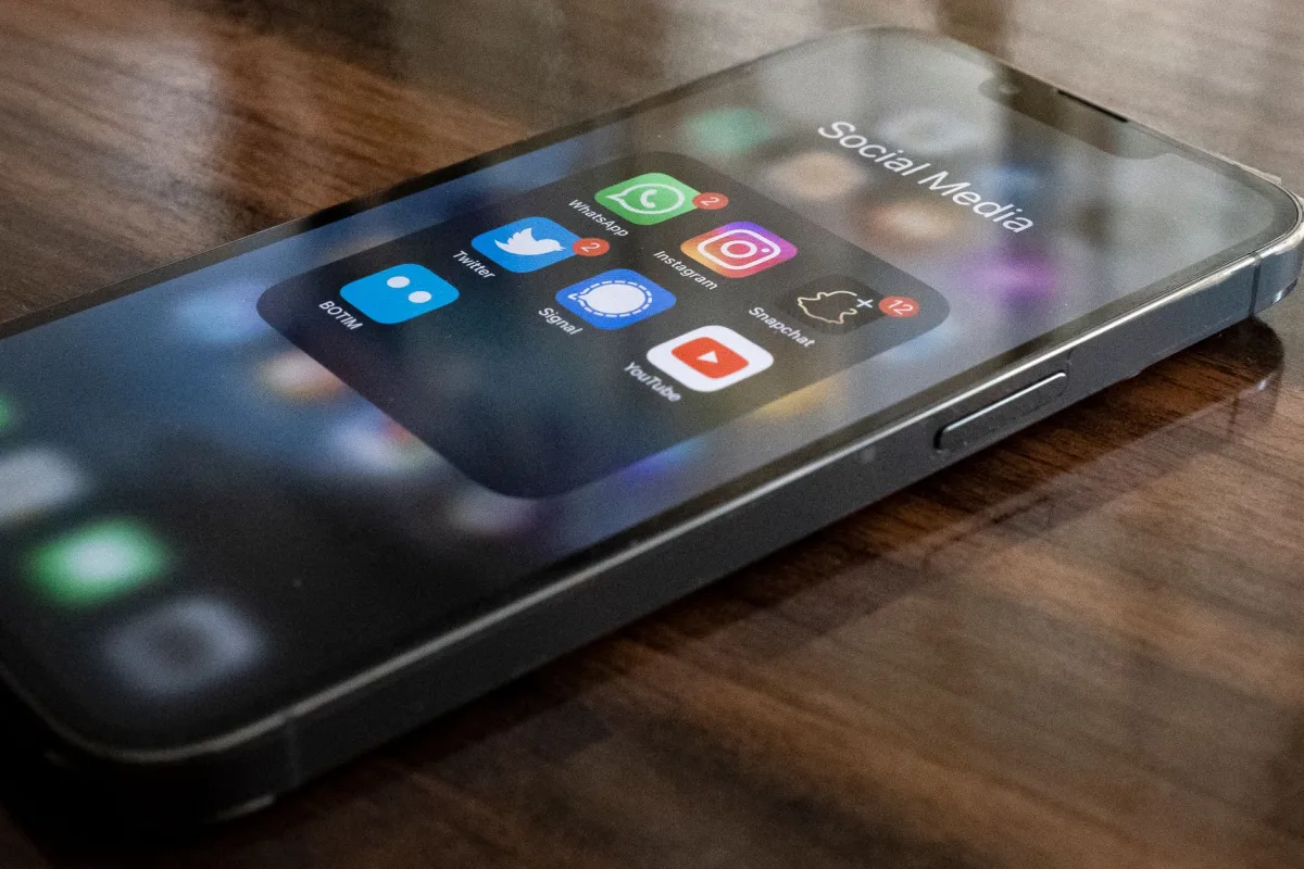 Close-up of smartphone on table showing various social media app icons including WhatsApp and Instagram. Close-up of smartphone on table showing various social media app icons including WhatsApp and Instagram.