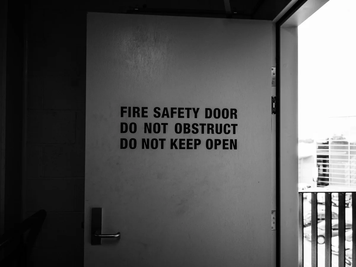 Black and white image of fire safety door with warning instructions. Black and white image of fire safety door with warning instructions.