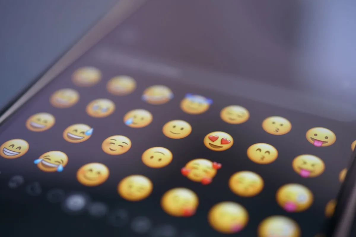 A close-up view of various emojis on a smartphone screen, symbolizing digital communication and social media use. A close-up view of various emojis on a smartphone screen, symbolizing digital communication and social media use.
