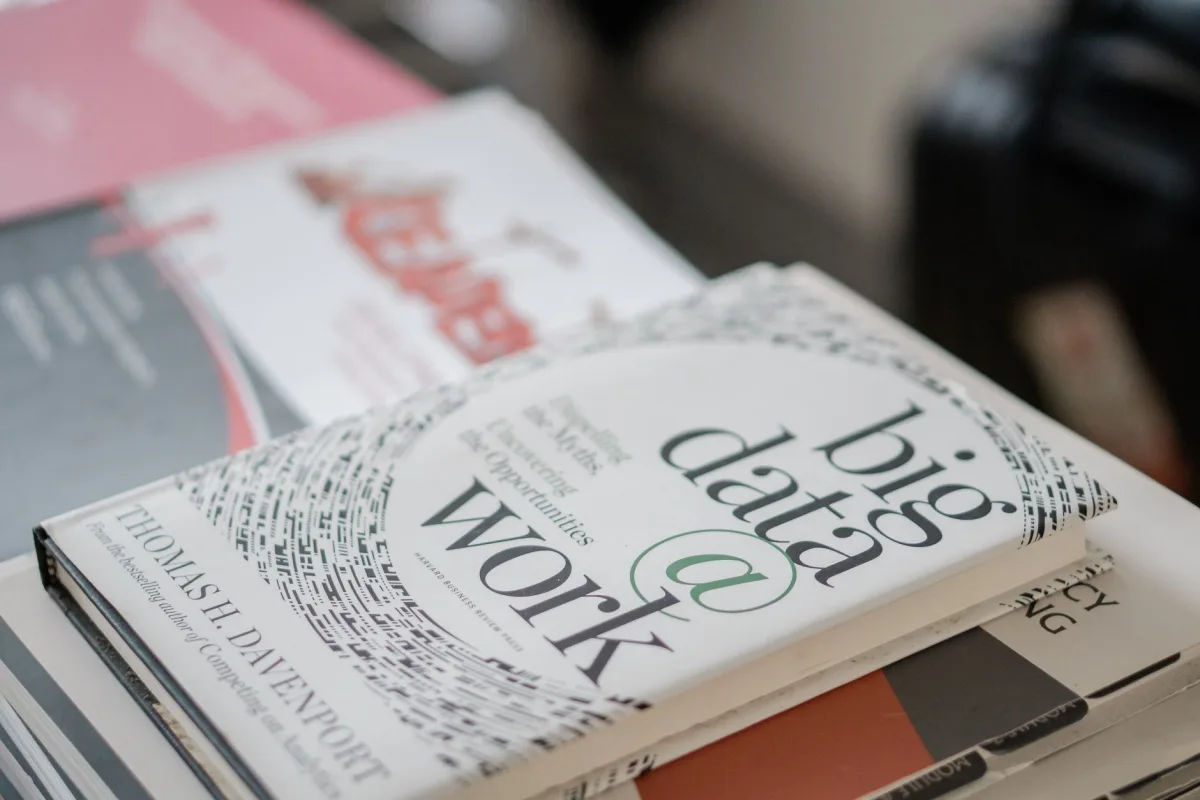 Close-up of books on data analytics and business on a desk. Close-up of books on data analytics and business on a desk.