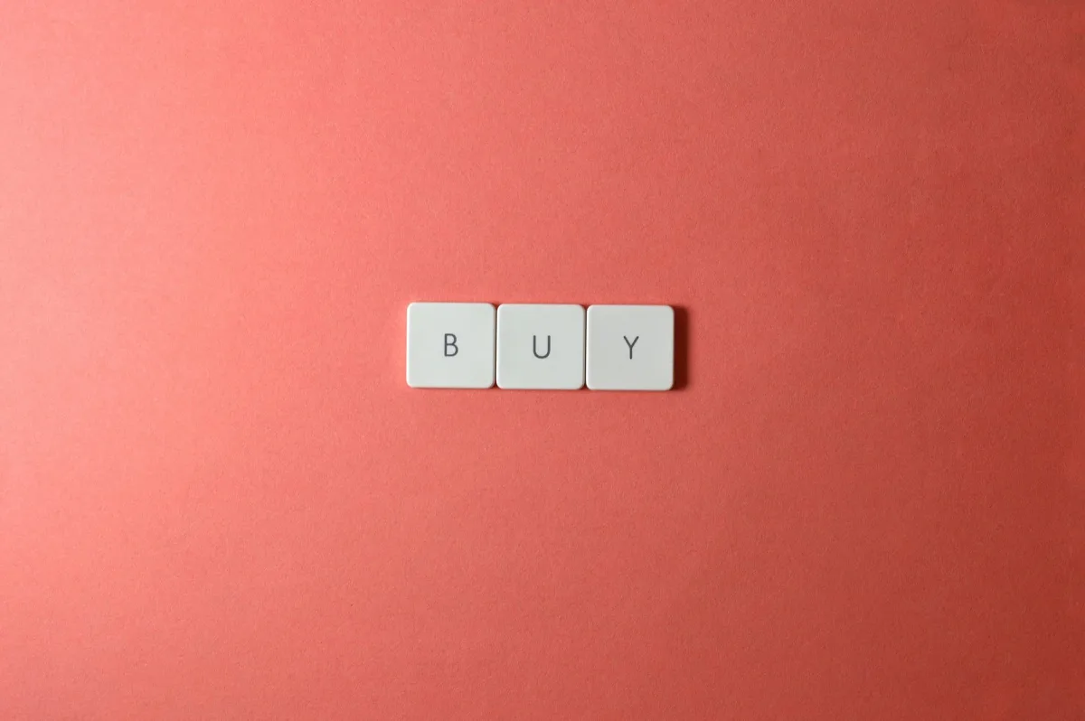 Keyboard keys spelling 'BUY' on a coral background, ideal for e-commerce themes.