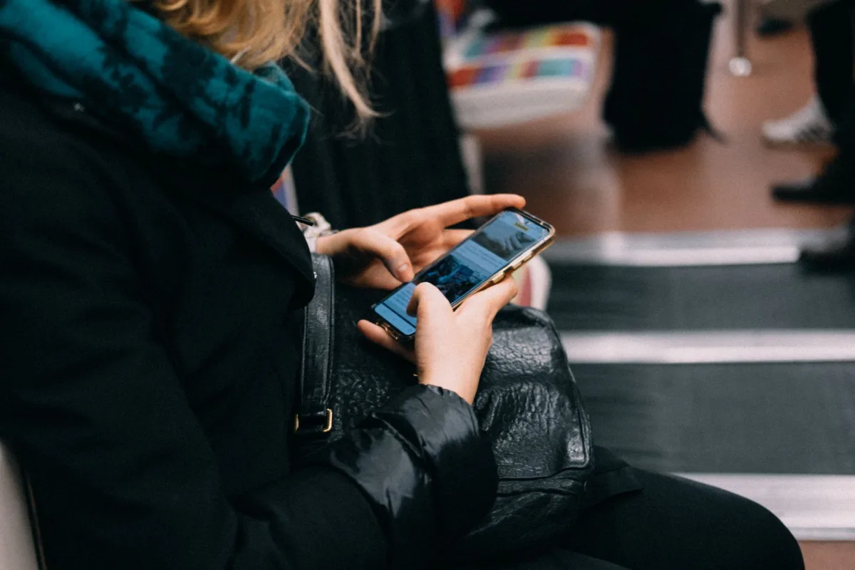 A woman uses her smartphone while commuting on public transportation.