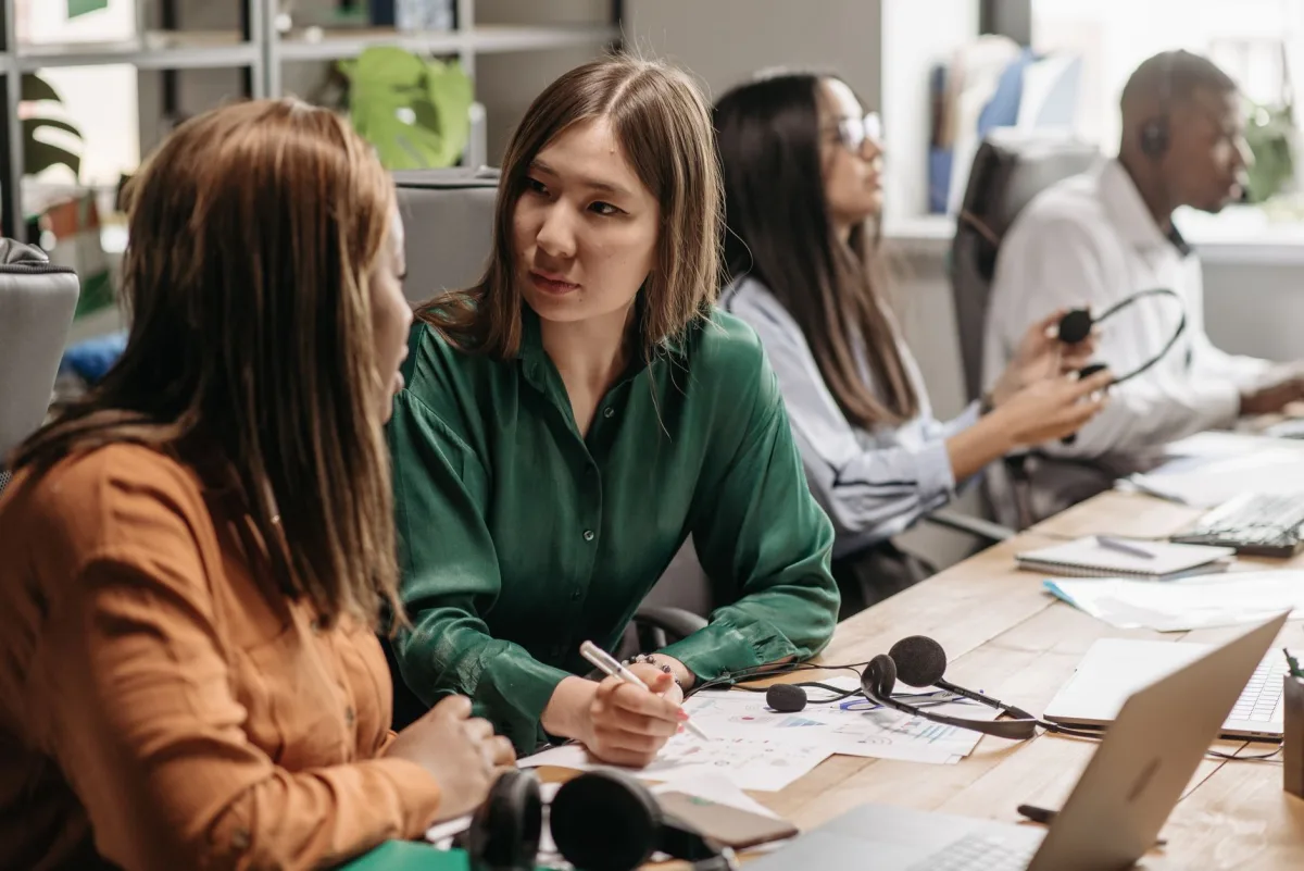 A diverse group of colleagues engaging in teamwork at a modern office workspace. A diverse group of colleagues engaging in teamwork at a modern office workspace.
