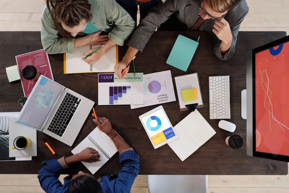Overhead view of a diverse team collaborating on a project in a modern office setting. Overhead view of a diverse team collaborating on a project in a modern office setting.
