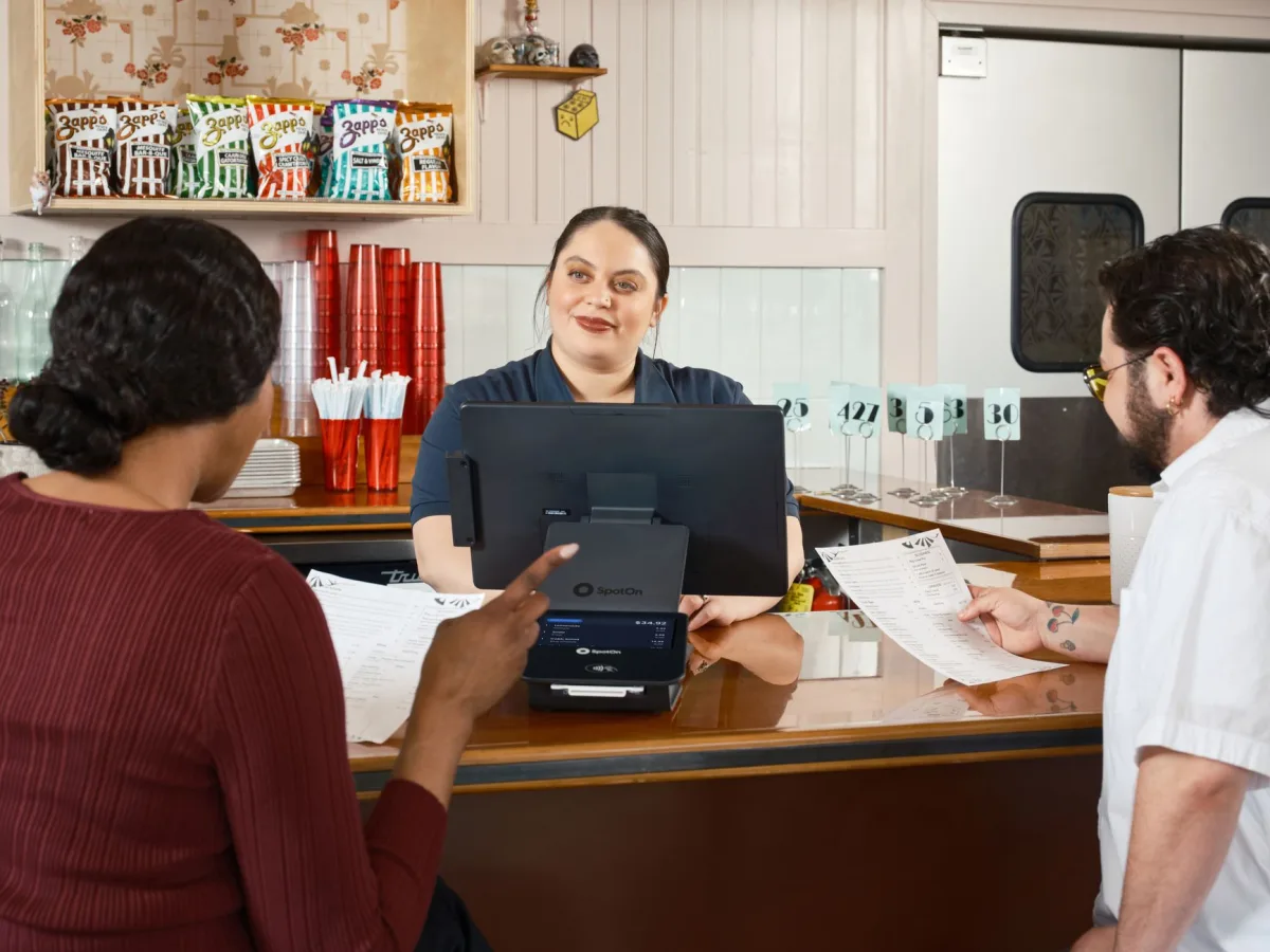 Restaurant staff take orders at a POS system, showcasing modern dining technology. Restaurant staff take orders at a POS system, showcasing modern dining technology.