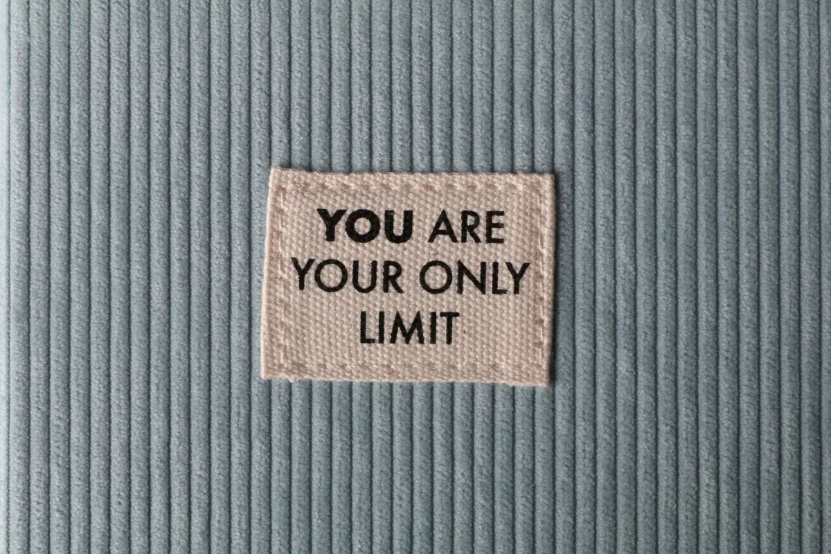 Fabric patch on blue velvet with motivational text 'You Are Your Only Limit' in close-up view.