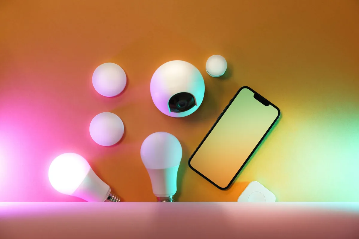 A collection of home devices including light bulbs and a smartphone, showcasing modern technology.