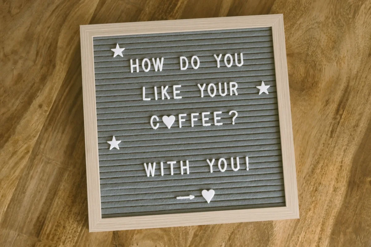A cute, romantic coffee-themed message displayed on a felt letter board with decorative stars and hearts.