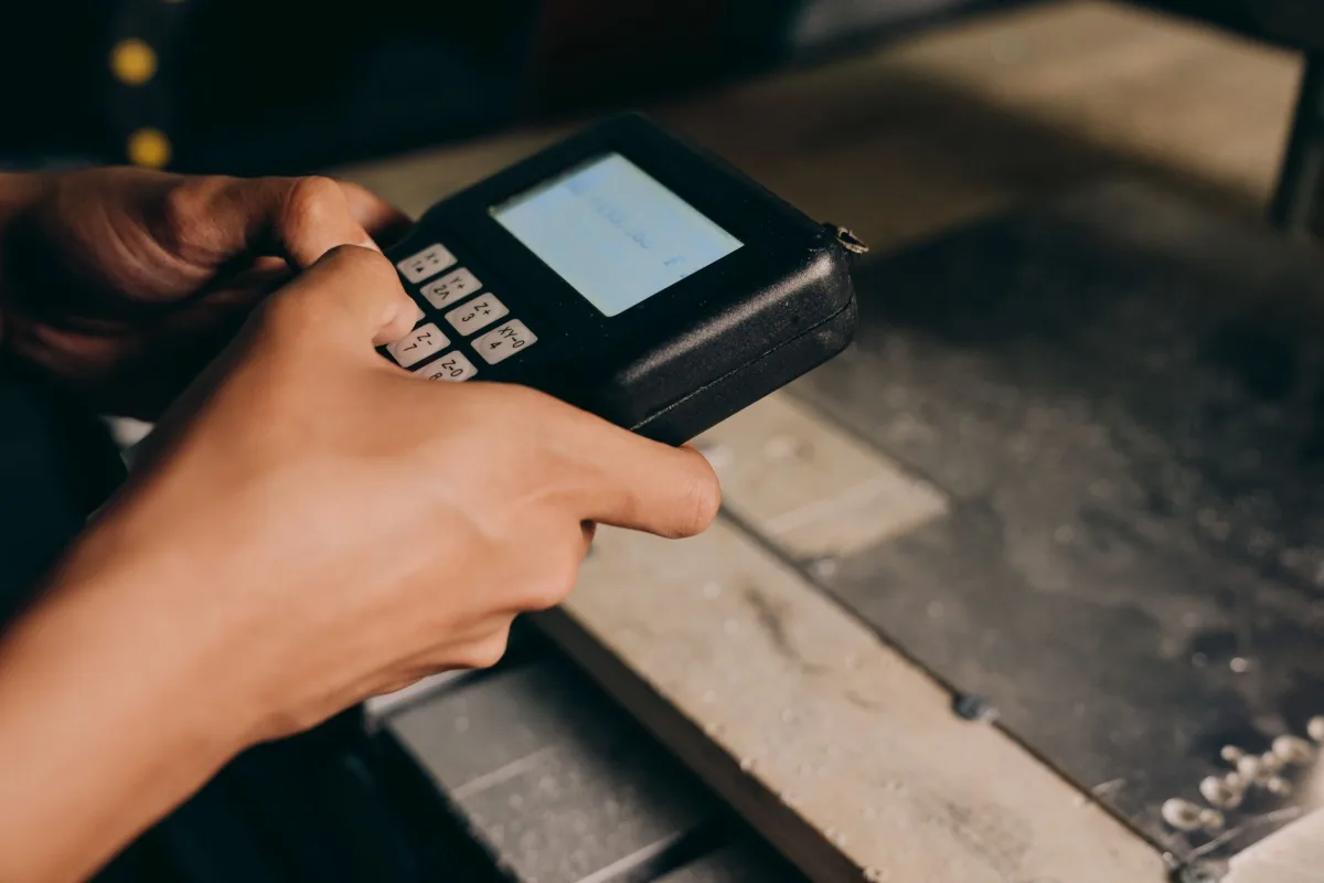 A detailed close-up of hands operating an electronic control device, capturing the precision of modern technology use. A detailed close-up of hands operating an electronic control device, capturing the precision of modern technology use.