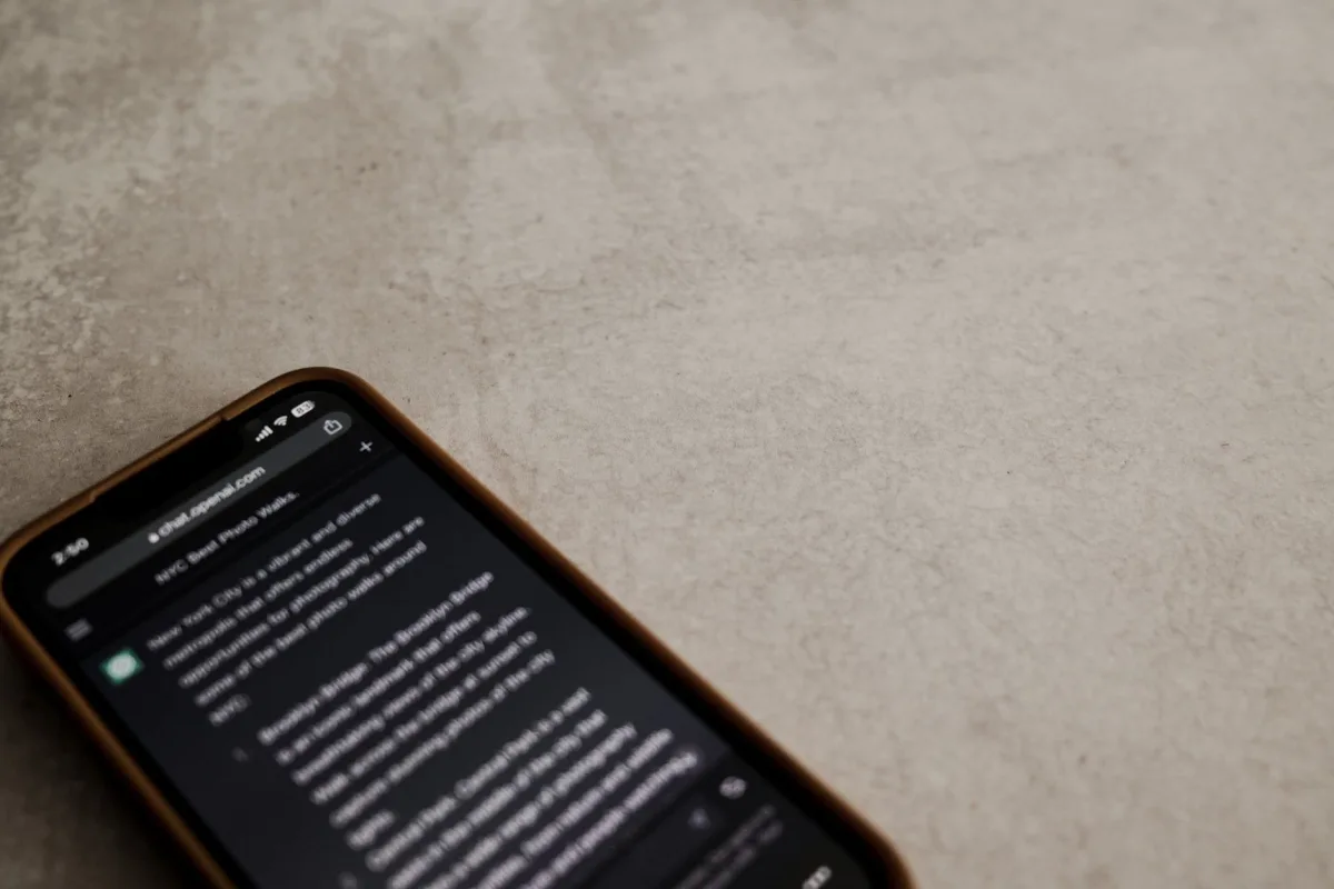Close-up view of a smartphone displaying a chat interface on a textured surface.