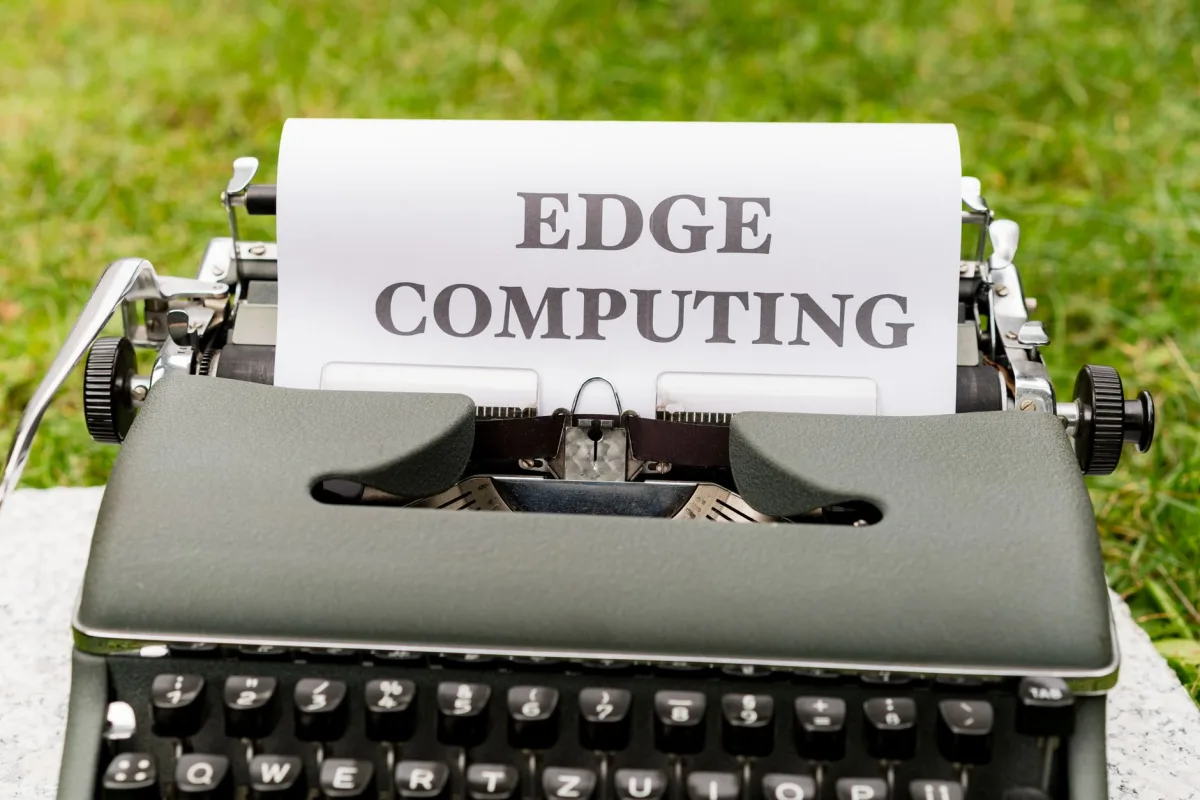 A vintage typewriter outdoors typing 'EDGE COMPUTING' on paper, blending technology with nostalgia. A vintage typewriter outdoors typing 'EDGE COMPUTING' on paper, blending technology with nostalgia.