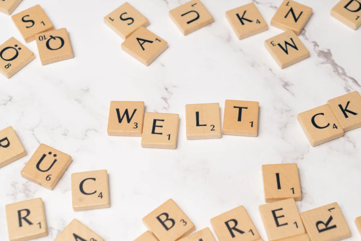 Scattered wooden letter tiles on a marble background spelling 'WELT'. Perfect for creative and educational designs. Scattered wooden letter tiles on a marble background spelling 'WELT'. Perfect for creative and educational designs.