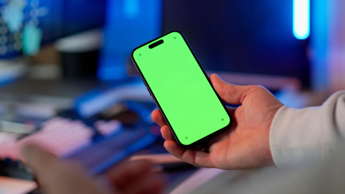 Hand holding smartphone with green screen in modern indoor setting, ready for app design or mockup. Hand holding smartphone with green screen in modern indoor setting, ready for app design or mockup.