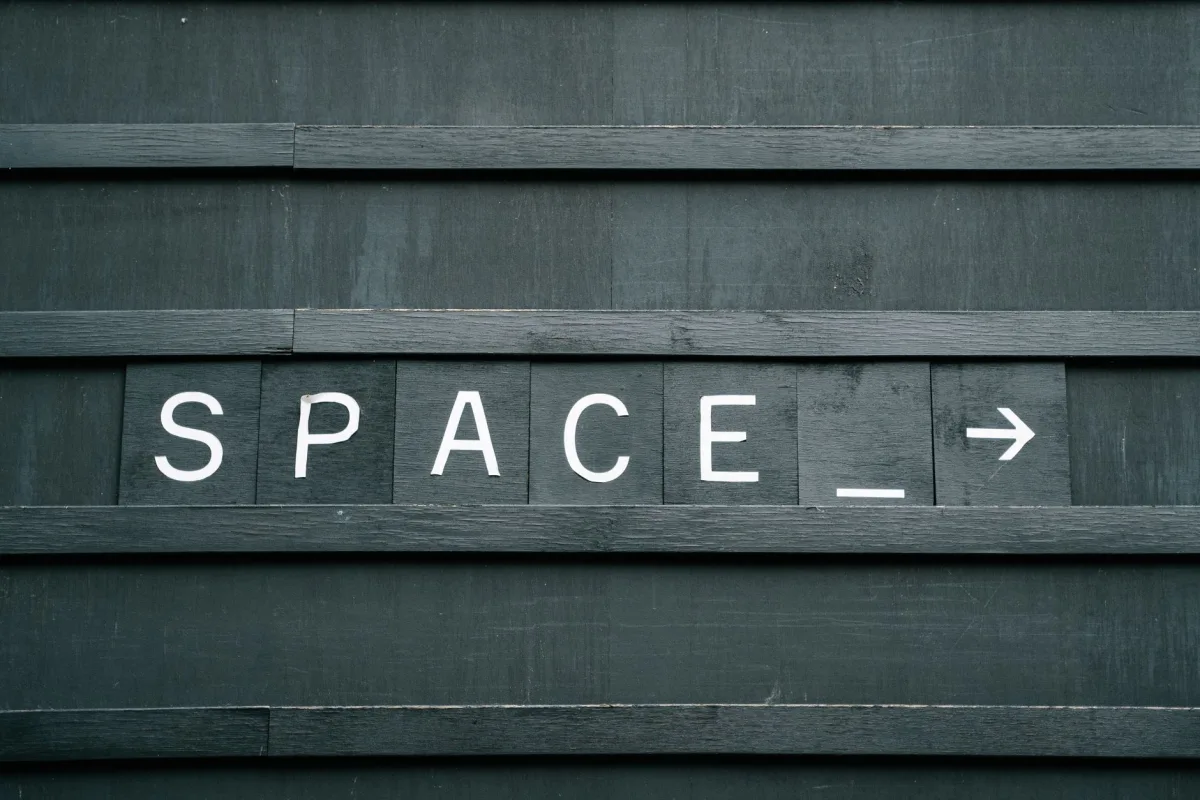 Close-up of minimalist wooden sign with 'SPACE' in capital letters and an arrow, creating conceptual theme. Close-up of minimalist wooden sign with 'SPACE' in capital letters and an arrow, creating conceptual theme.