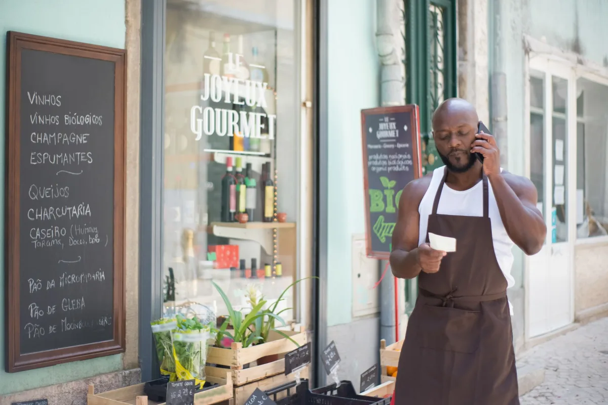 grocery store vendor making phone call at gourmet shop in Lisbon, Portugal.