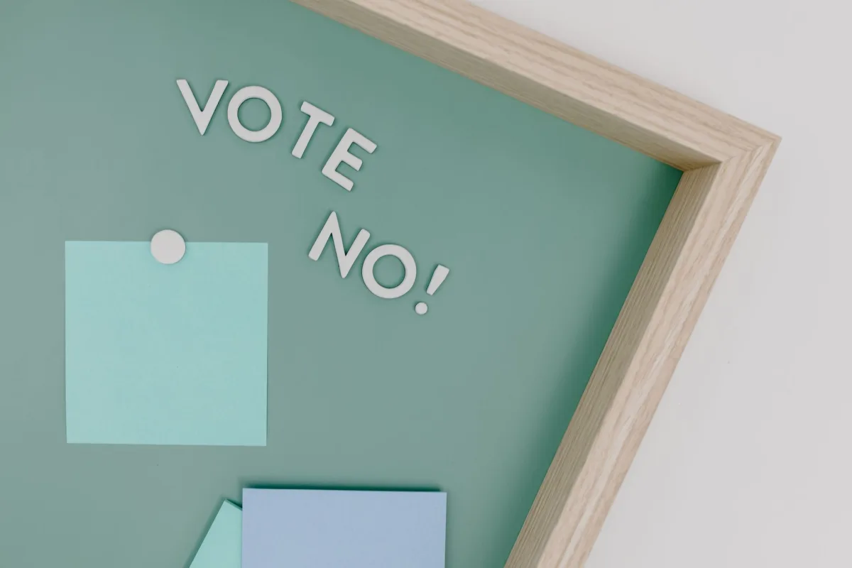 Creative conceptual image of a framed 'Vote No' sign on a green board.