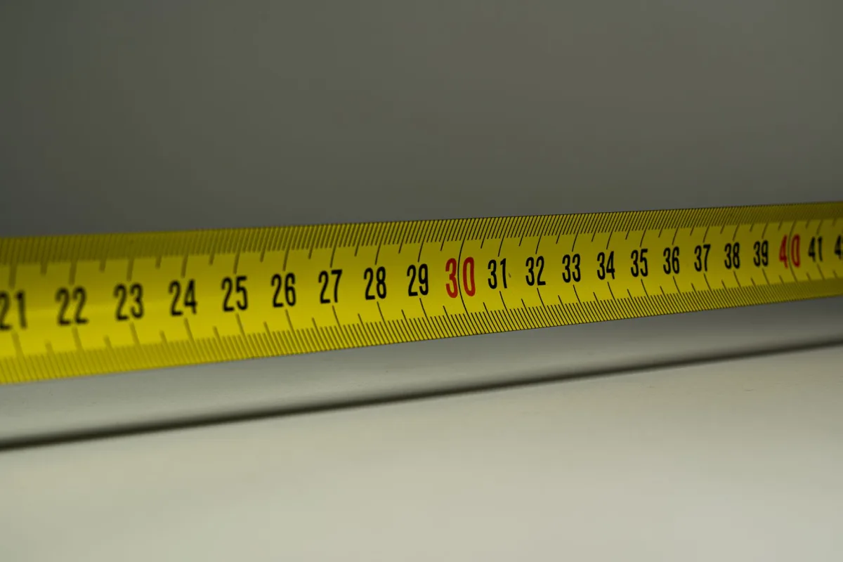 Close-up view a yellow measuring tape with centimeter marks, emphasizing precision in measurement. Close-up view a yellow measuring tape with centimeter marks, emphasizing precision in measurement.