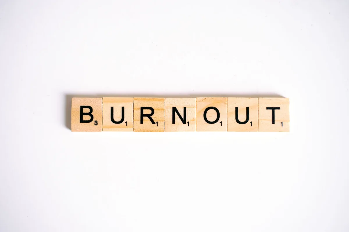 Conceptual image of 'Burnout' spelled with Scrabble tiles on a white background.