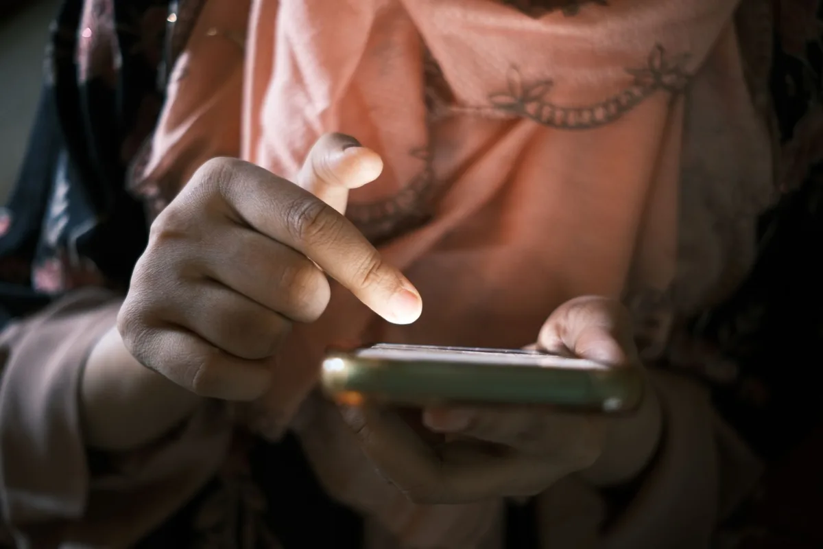 Close-up of hands using a smartphone indoors, highlighting touch technology. Close-up of hands using a smartphone indoors, highlighting touch technology.