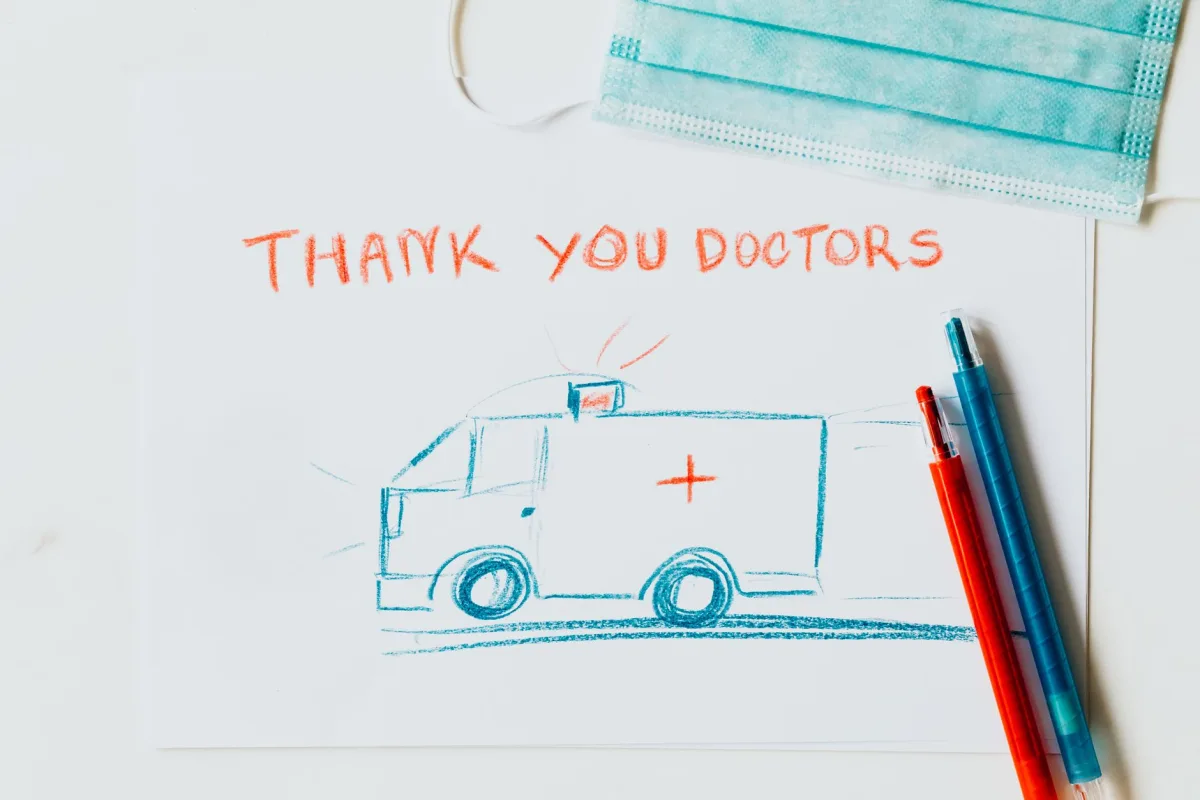 heartfelt drawing thanking doctors with an ambulance illustration, face mask, and pens.