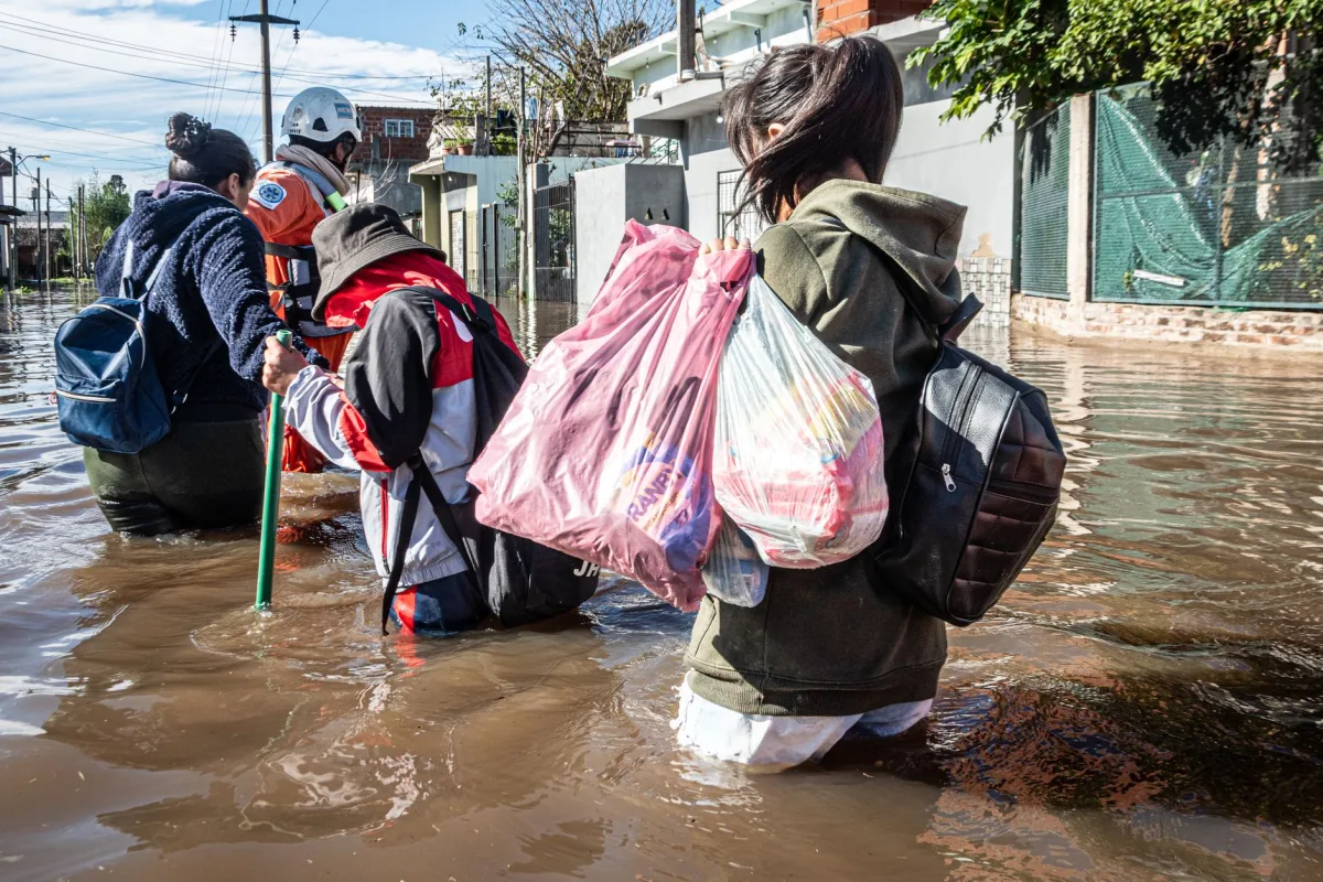 Rescue team aids flood victims wading through water in Buenos Aires, Argentina.