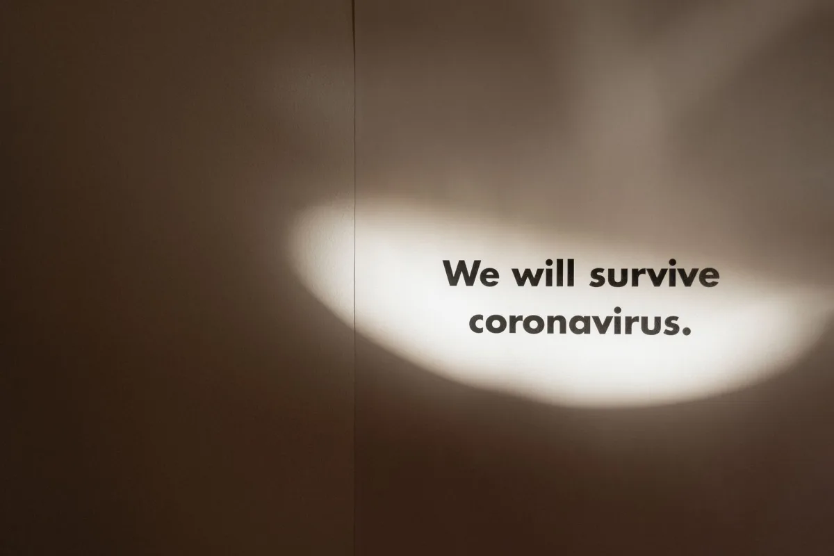 Motivational text "We will survive coronavirus" with spotlight effect.