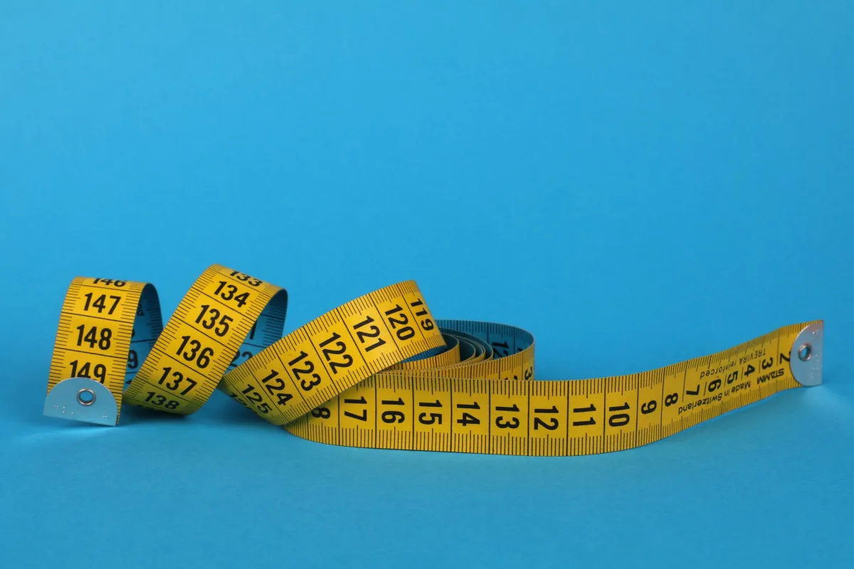 Coiled yellow tape against a vibrant blue background, offering ample copy space. Coiled yellow tape against a vibrant blue background, offering ample copy space.