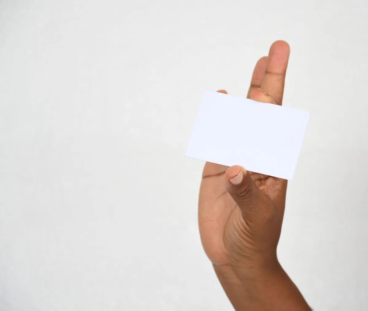 A close-up of a hand holding a blank card, ideal for copy space.