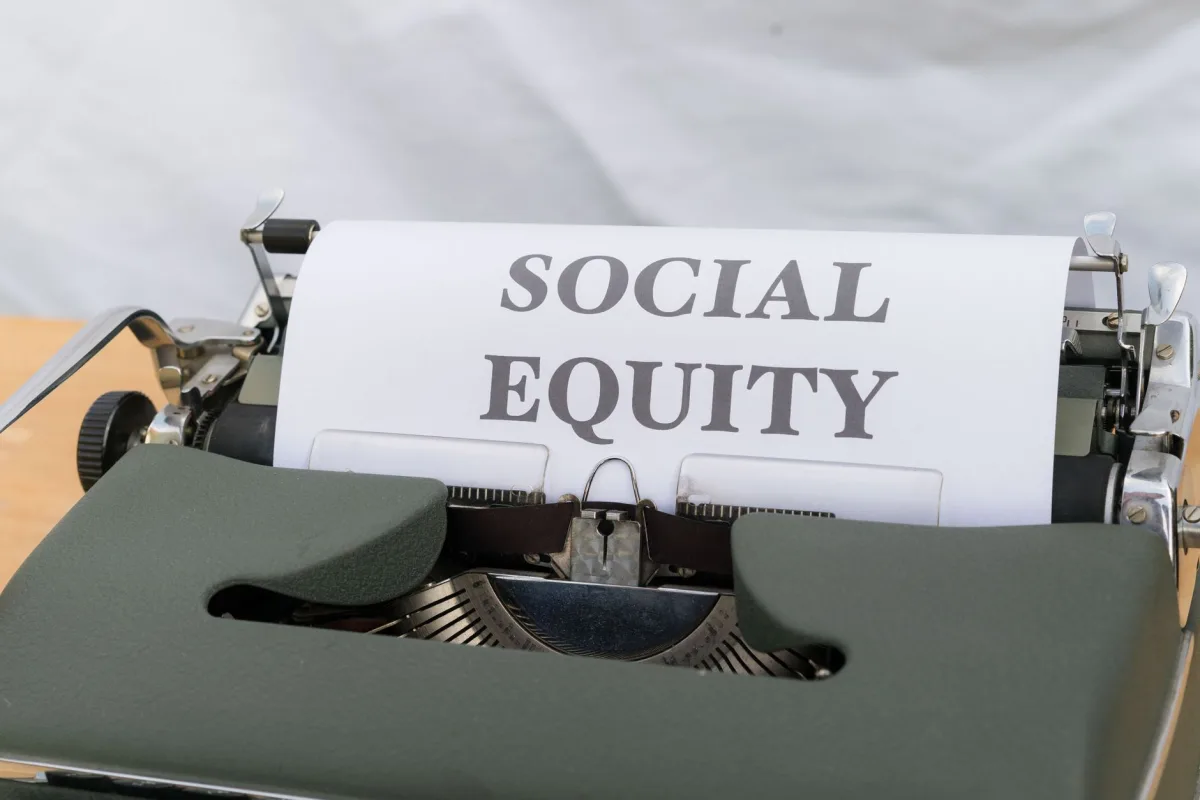 Close-up of a vintage typewriter displaying the message 'Social Equity' on paper. Close-up of a vintage typewriter displaying the message 'Social Equity' on paper.