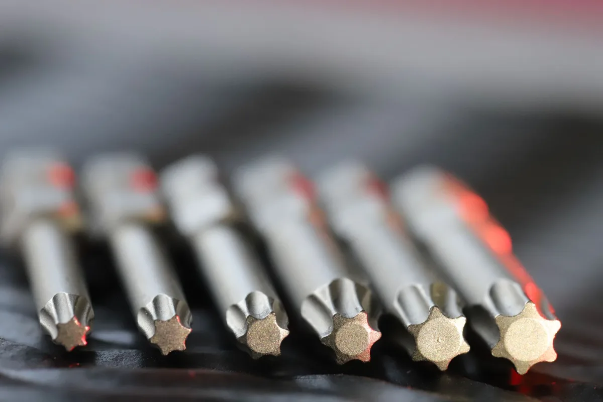 Macro shot of metal precision drill bits with star-shaped in a row, emphasizing detail and craftsmanship. Macro shot of metal precision drill bits with star-shaped in a row, emphasizing detail and craftsmanship.