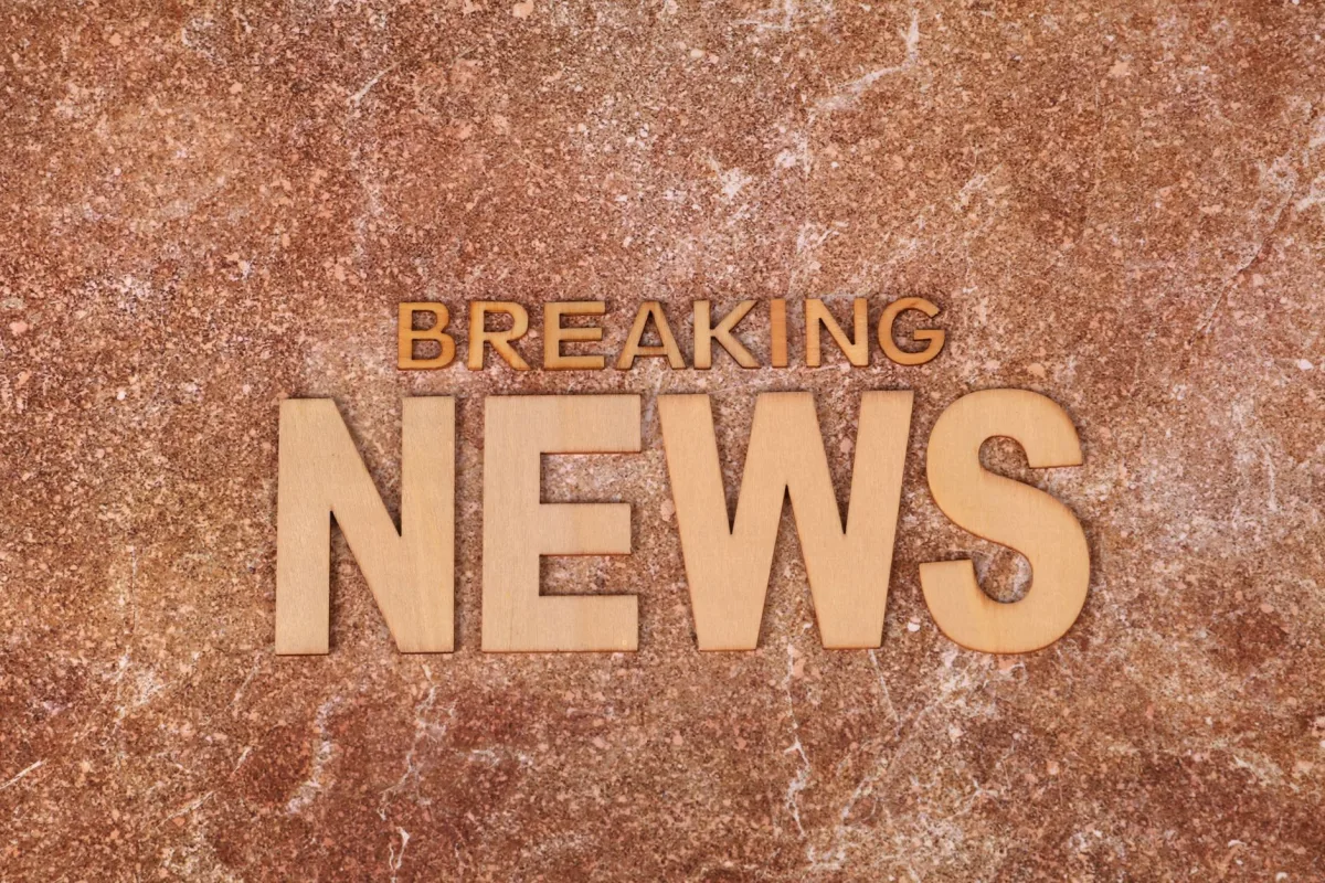Wooden letters spell 'Breaking News' on a textured, marble-like background. Ideal newsworthy content.